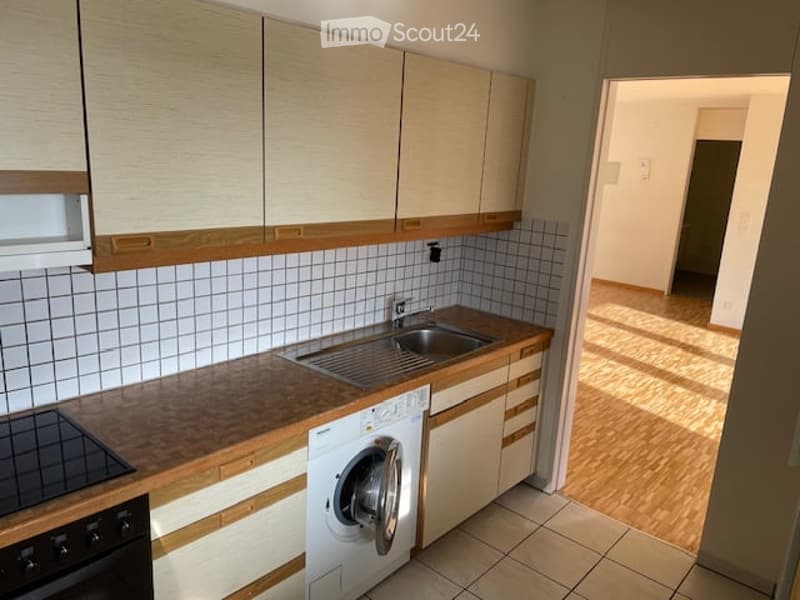 kitchen with wooden cabinets, tiled floor, sink, washing machine, stove, wooden countertop