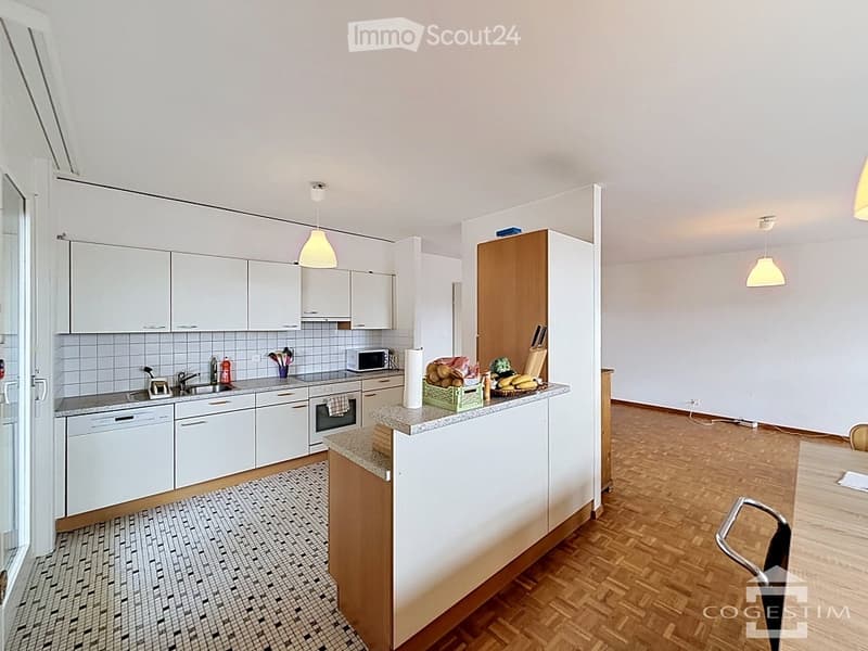 Modern kitchen with white cabinets, granite countertop, and wooden flooring. Includes a sink, microwave, oven, and dishwasher.
