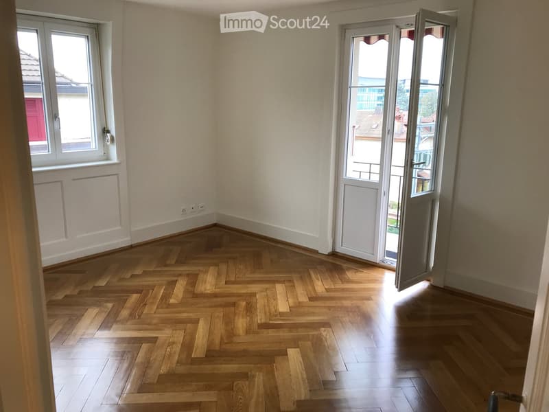 empty room, wooden parquet floor, white walls, two windows, open balcony door