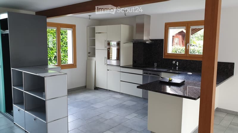 Modern kitchen with white cabinets, stainless steel appliances, black granite countertops, and a built-in sink with a faucet.