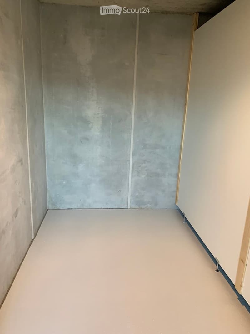 Empty room with bare concrete walls and a smooth, light-colored floor. No furniture or equipment present.