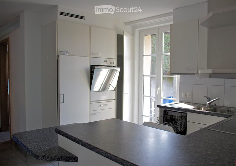 Modern kitchen with white cabinets, granite countertop, stainless steel appliances including a refrigerator, oven, dishwasher, and sink.