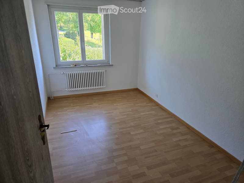 Empty room with wooden flooring, white walls, and a window with a radiator below it. No furniture or equipment is present.