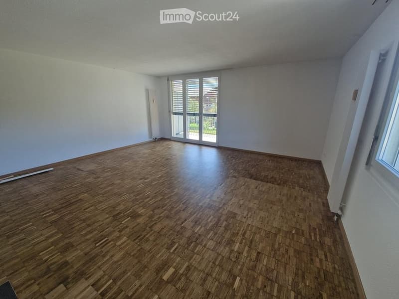 Completely empty room with wooden flooring and white walls. No furniture or equipment.