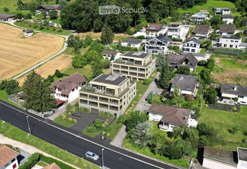 Aerial view of a residential area with multiple houses, garages, and parking spaces.