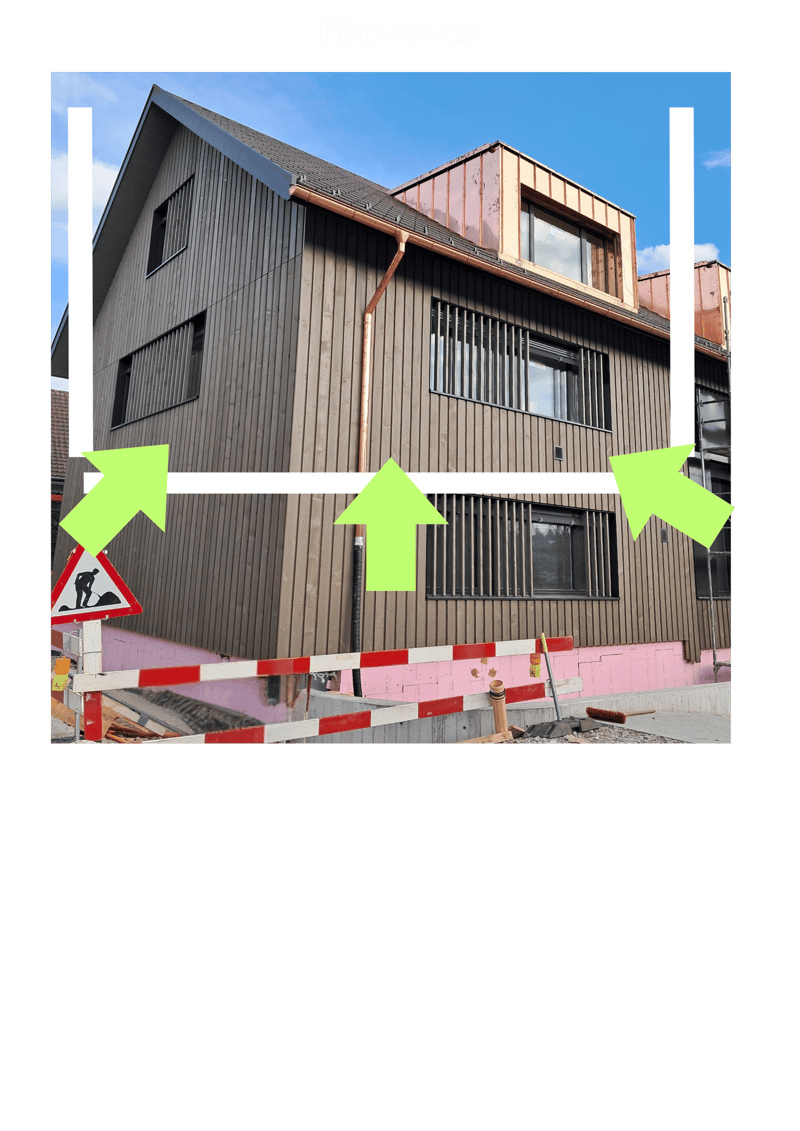 Modern two-story building with wooden facade, multiple windows, and a raised ground floor area with construction barriers and tools.