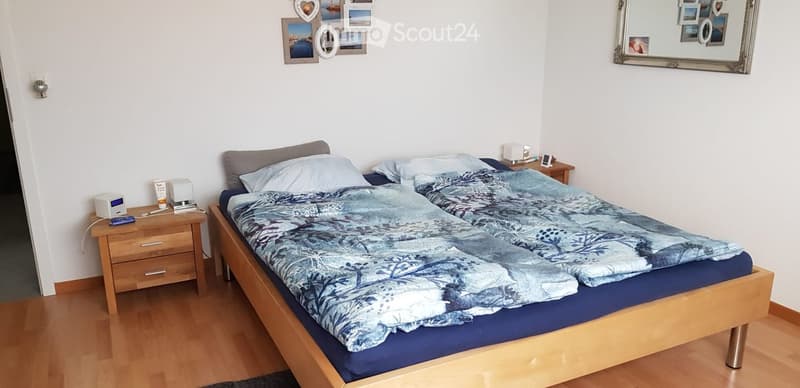 Cozy bedroom with a double bed, nightstands, and a mirror on the wall.