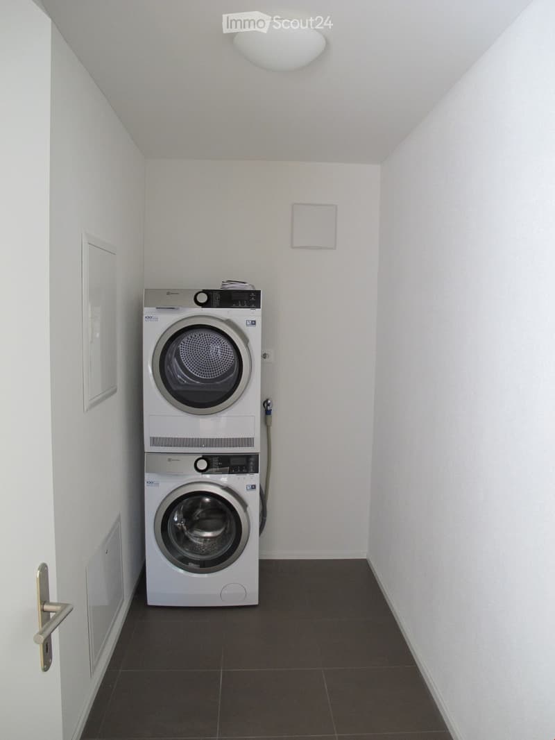 Small utility room with stacked washer and dryer