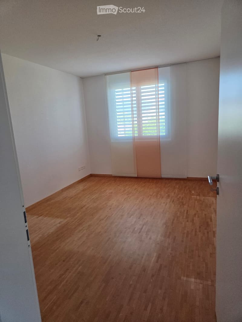 Empty room with wooden flooring, white walls, and a window with blinds. No furniture or equipment is present.