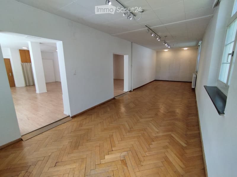 Empty room with wooden herringbone flooring, white walls, and recessed lighting. No furniture or equipment present.