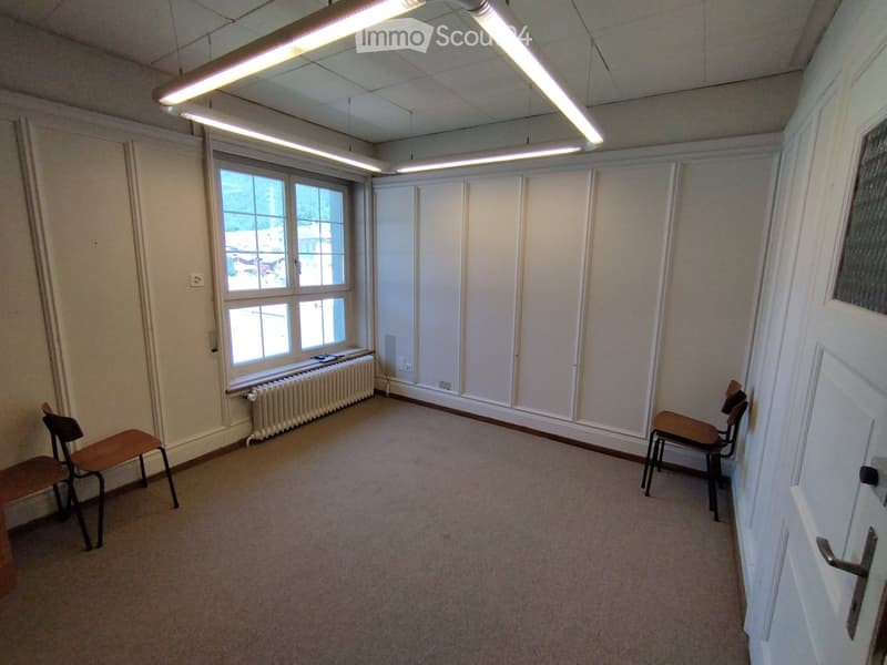Empty room with carpeted floor, white walls, large windows, and two chairs near the windows.