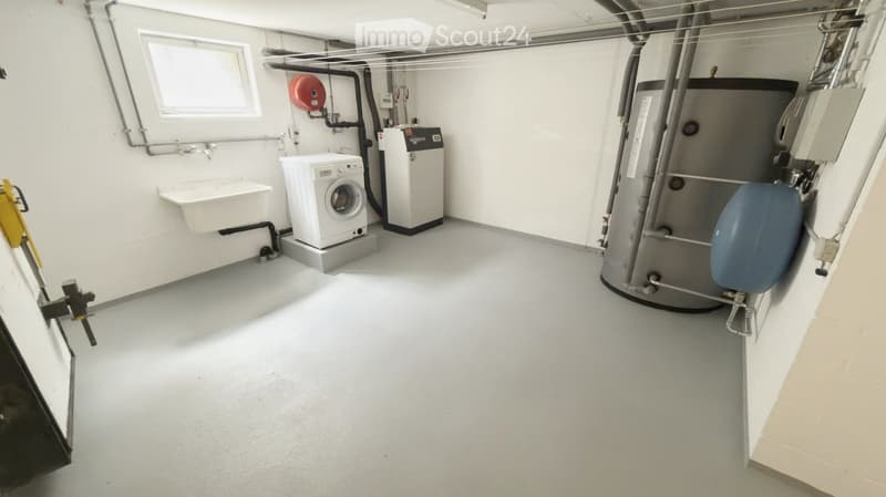 Utility room with white walls, a washing machine, a dishwasher, a water heater, and a sink.