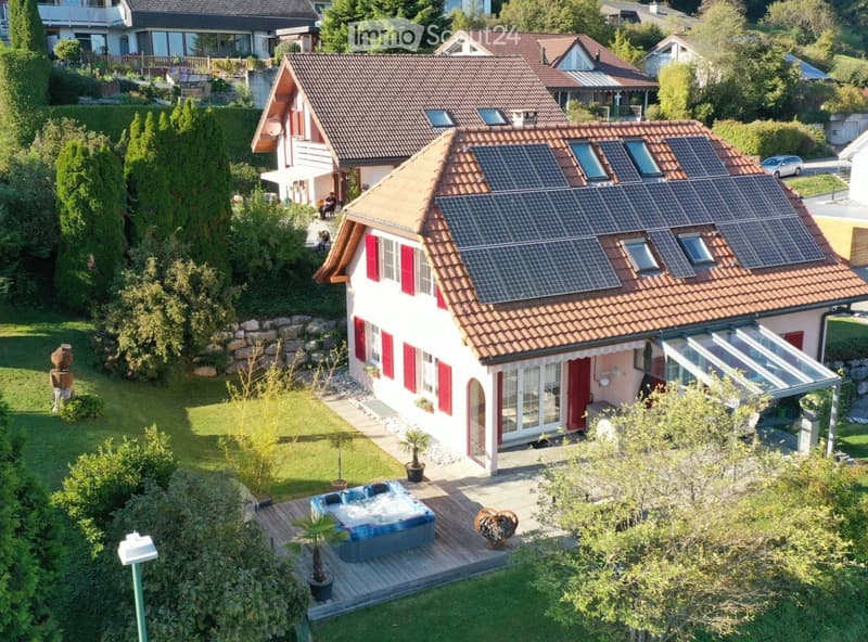 Single family house, modern style, solar panels on the roof, jacuzzi in the garden, raised ground floor, large windows, red shutters, spacious garden