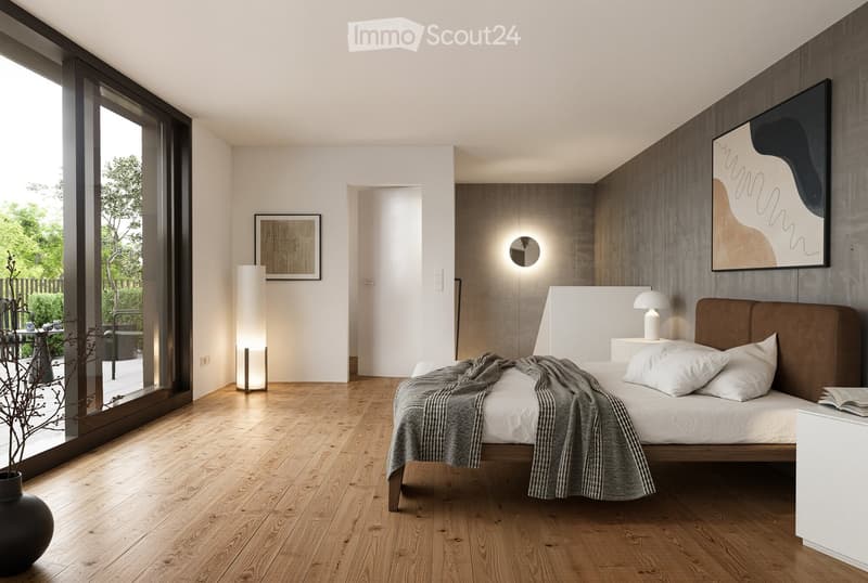 Modern bedroom with wooden flooring, large windows, a bed with white linens and a brown headboard, nightstand with a lamp, floor lamp, and artwork on the walls.