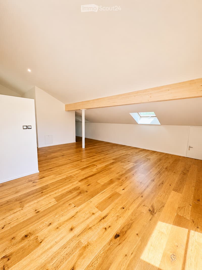 Empty room with wooden flooring, white walls, and a skylight window. No furniture or equipment present.