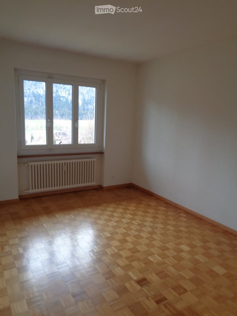 Empty room, white walls, parquet floor, white window with a view of the mountains