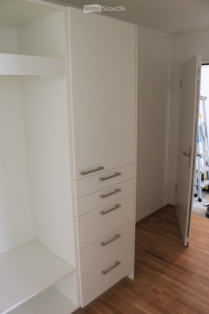 Empty room with white built-in wardrobe and wooden flooring. No furniture or personal items visible.