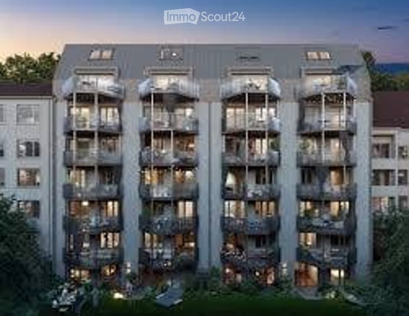 Modern multi-story apartment building with multiple balconies and large windows, surrounded by greenery.