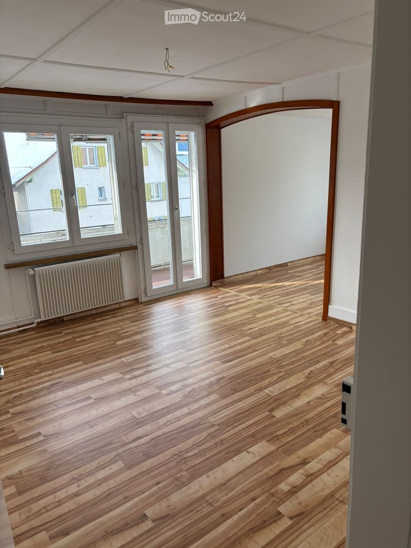 Hardwood flooring, sliding glass doors to balcony, windows, white walls, balcony with view, central heating radiator