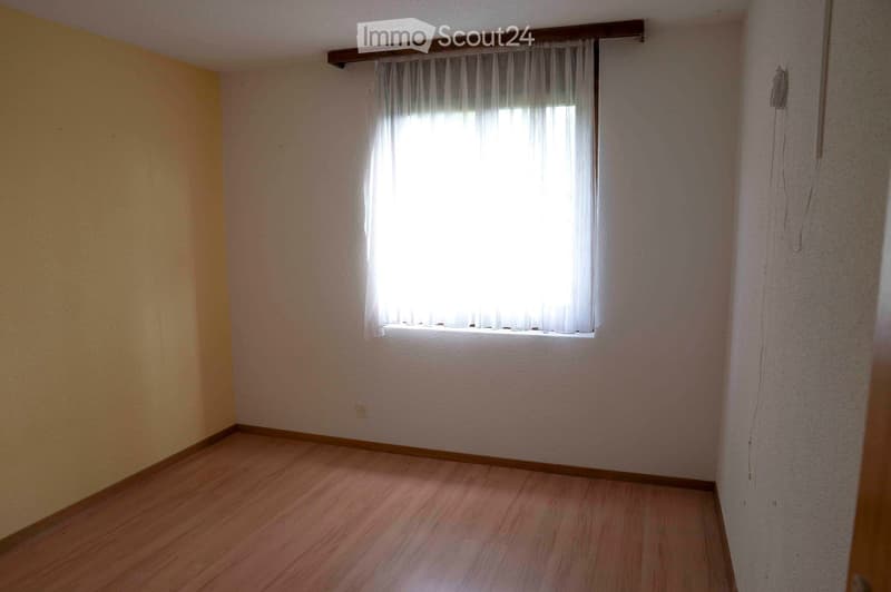 empty room, yellow wall, wooden floor, white walls, power outlet, window with white curtains