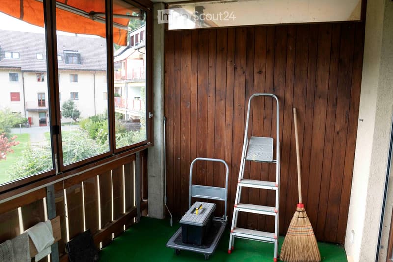 wooden railing, wooden floor, green flooring, view of a yard, broom, ladder, toolbox
