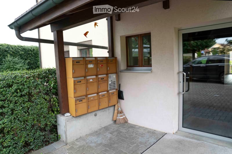 building exterior, mailbox with several compartments, a broom, a glass door with a handle, and a glass window.