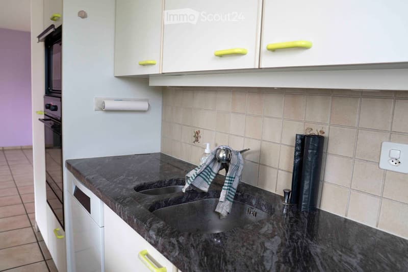 white cabinets, granite countertop, double sink, towel hanging from faucet, dishwasher