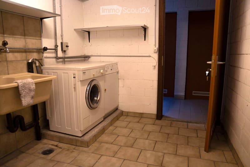 laundry room, sink, white washing machine, open door, tiled floor