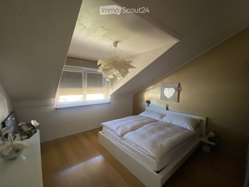 bedroom with sloping ceiling, bed, nightstands, window, photo frame, wooden floor