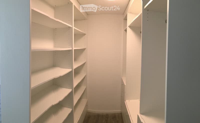 walk-in closet with white shelves and hardwood floor
