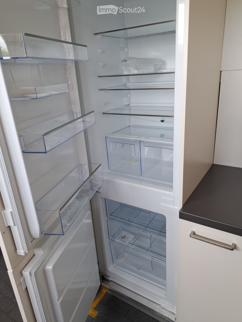 Open refrigerator with multiple glass shelves and compartments, showing a clean and organized interior.