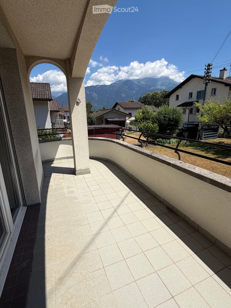 Balcony with tiled floor, curved design, metal railing, and scenic mountain view.