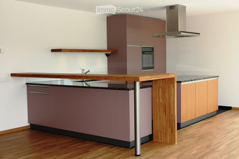 Modern kitchen with wooden countertops, stainless steel appliances, and built-in cabinets.