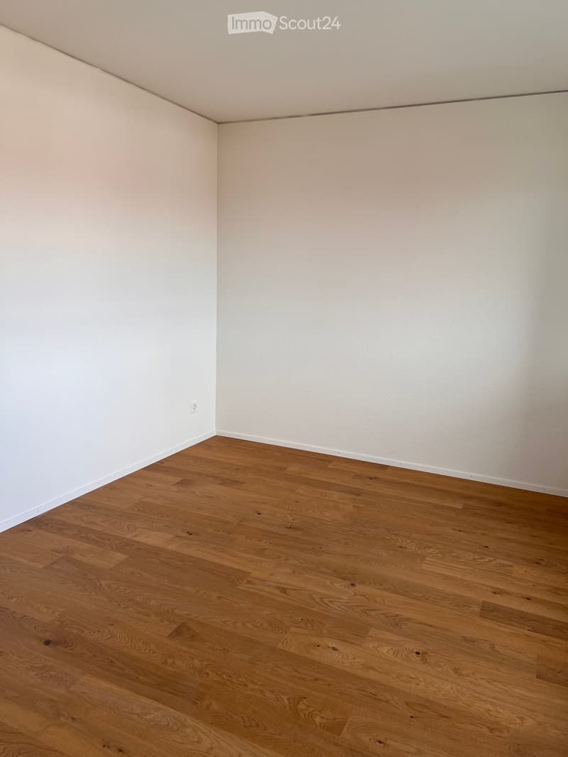 Completely empty room with bare white walls and wooden floor. No furniture or equipment.