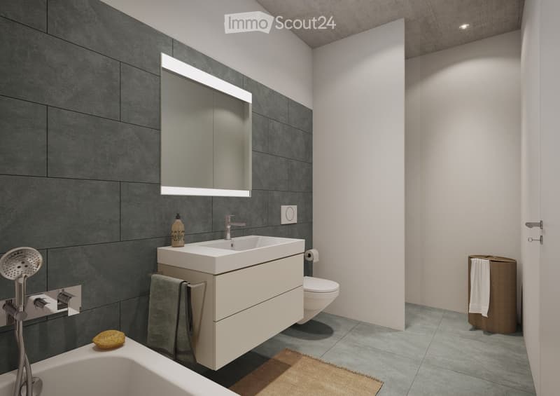 Modern bathroom with a bathtub, sink, toilet, and showerhead. Features a large mirror with built-in lighting, a towel rack, and a small basket with a towel.