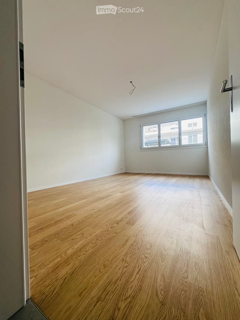 Empty room with wooden flooring, white walls, and a window with white frame. No furniture or equipment present.