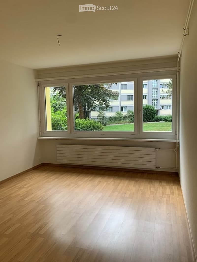 empty room, wooden floor, large window, white walls, radiator
