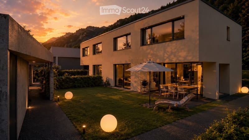 Modern house with a well-maintained garden, featuring a patio area with a table, chairs, umbrella, grill, lounge chair, and decorative ball lights.