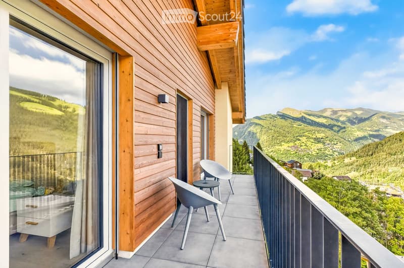 Balcony with wooden walls, modern chairs, and a view of the mountains.