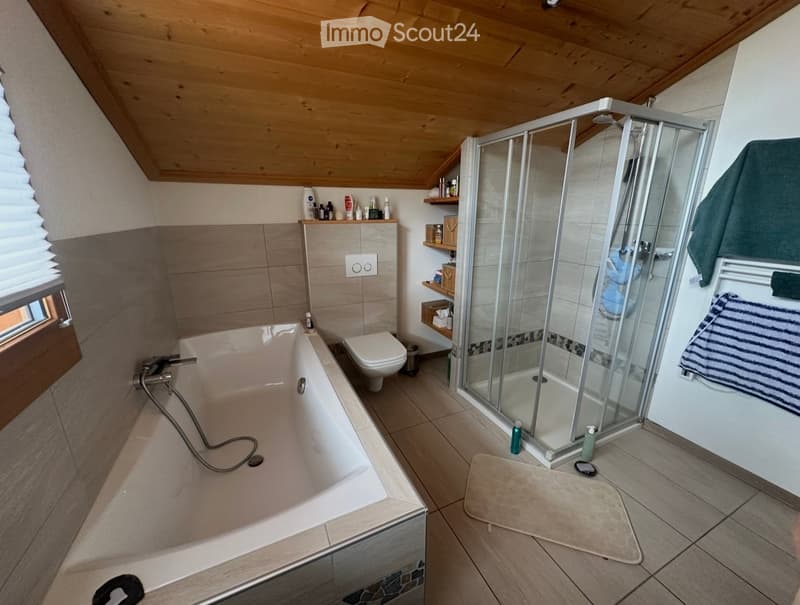Bathroom with bathtub, shower, toilet, wooden ceiling, tiled floor, shelves, towels, toiletries
