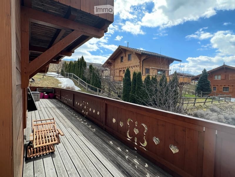 wooden deck, wooden railing, wooden chair, heart designs on railing, view of mountains