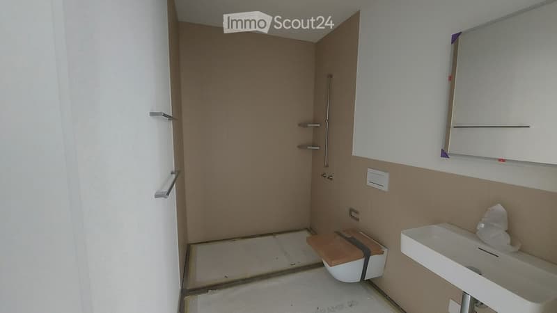 Modern bathroom with white walls, a white sink, a toilet, a mirror, and a cabinet. The floor is tiled, and the shower area is enclosed with glass doors.