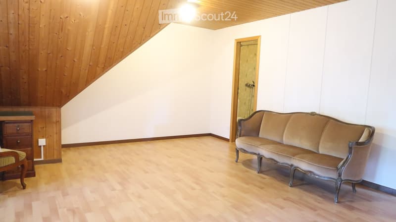 wooden ceiling, wooden floor, white walls, a couch, a wooden cabinet, a power outlet