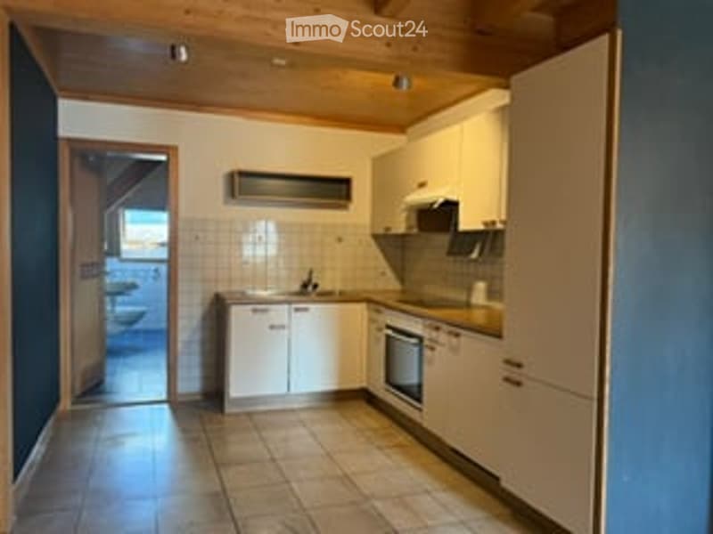 Modern kitchen with white cabinets, tiled floor, stainless steel appliances, and a sink.