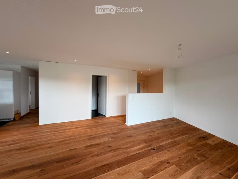 Empty room with wooden flooring, white walls, and recessed lighting. No furniture or equipment present.
