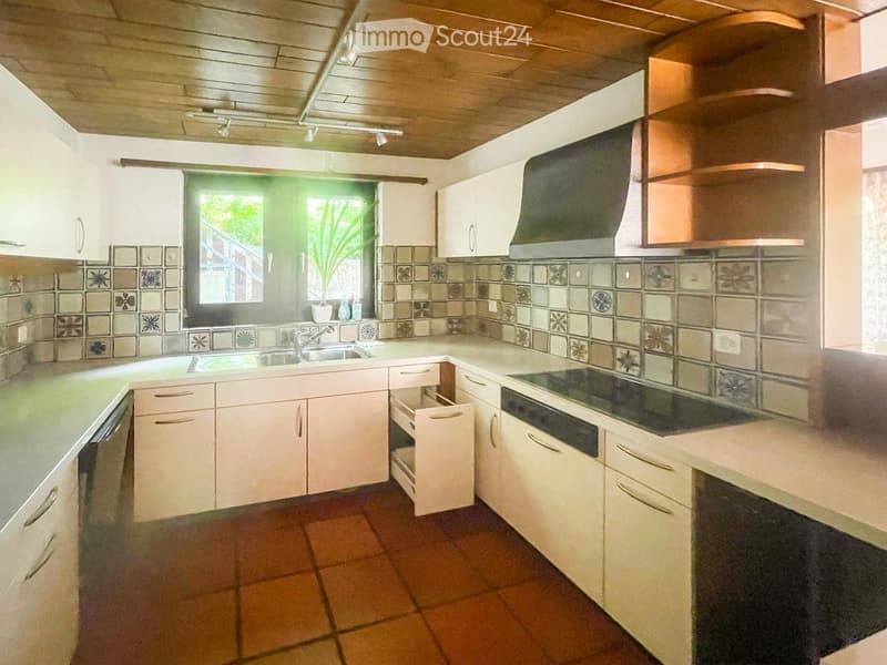 Modern kitchen with white cabinets, stainless steel appliances, and a tiled backsplash. Features a sink, stove, dishwasher, and ample cabinet space.