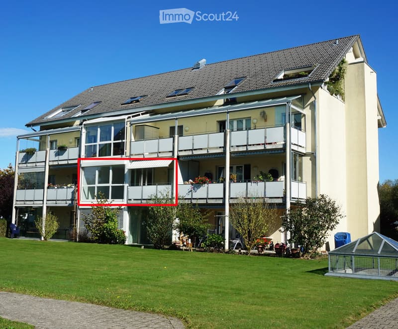 Modern two-story house with multiple balconies, large windows, and a well-maintained lawn.
