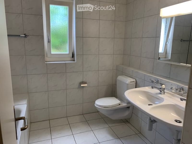 Bathroom with a toilet, bathtub, sink, and a mirror