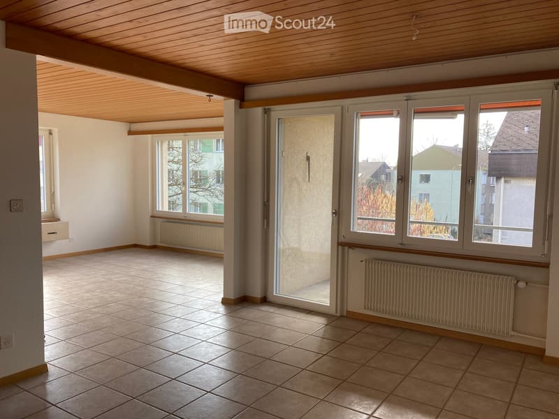 Empty room, wooden ceiling, tiled floor, glass door, windows, white walls, radiator