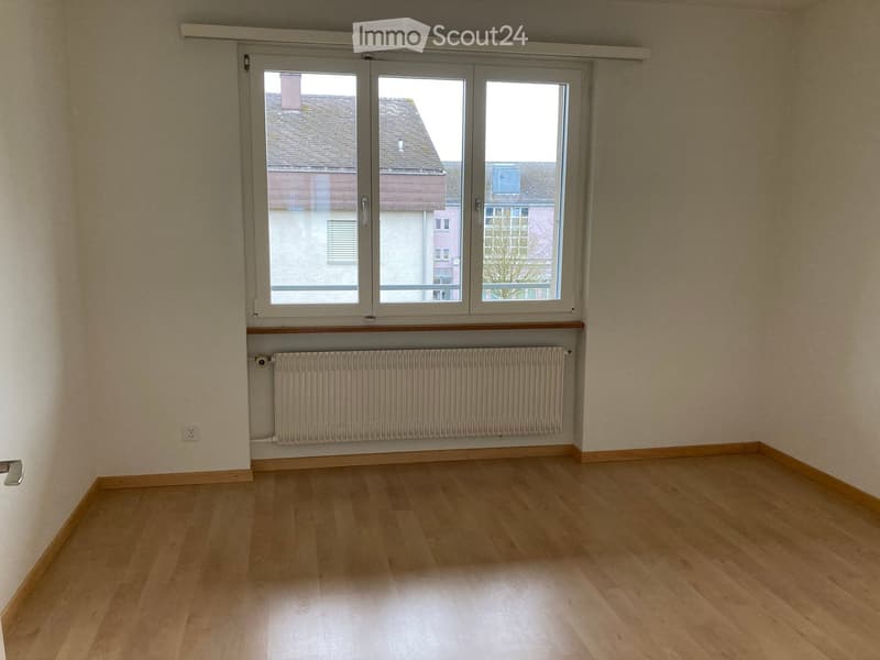 empty room, white walls, wooden floor, large window, white radiator